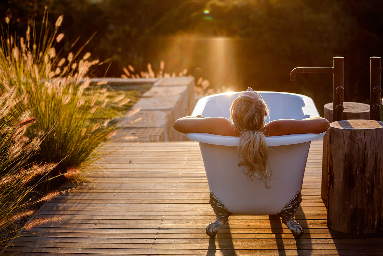 For a personal branding photography session a client site happily in the outdoor bath at sunset